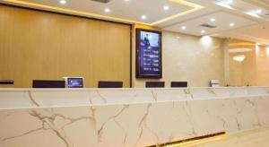 un hall d'entrée avec un grand comptoir avec des chaises et un écran dans l'établissement GreenTree Inn Xinjiang Kashgar Food Street, à Kachgar