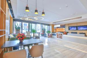 une salle à manger avec une table et des chaises dans l'établissement City Comfort Inn Yunfu Xinxing Juncheng Plaza, à Xinxing