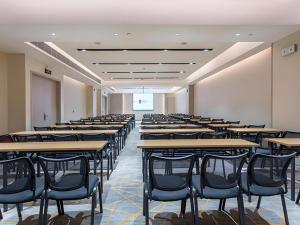 ein leerer Hörsaal mit Tischen und Stühlen in der Unterkunft Echarm Hotel Fangchenggang Qisha in Gongche