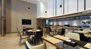 un restaurant avec des tables et des chaises et une cuisine dans l'établissement Echarm Hotel Liuzhou Yaobu Ancient Town, à Liuzhou