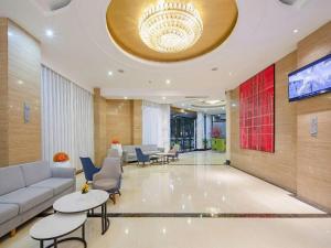 eine Lobby mit einem Sofa und Tischen und einem Kronleuchter in der Unterkunft Borrman Hotel Fangchenggang Cross-sea Bridge in Gongche