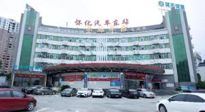a large building with cars parked in a parking lot at City Comfort Inn Huaihua East Station in Huaihua