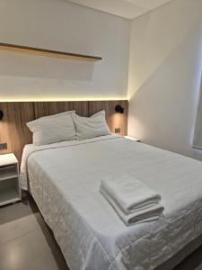 a bedroom with a white bed with towels on it at Molas Tower 119D in Asunción