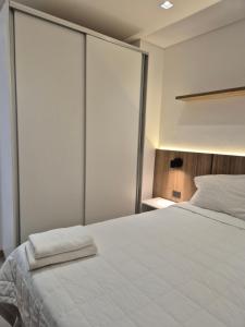 a bedroom with a large white bed with sliding glass doors at Molas Tower 119D in Asunción