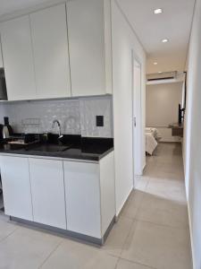 a kitchen with white cabinets and a sink at Molas Tower 119D in Asunción