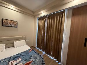 a bedroom with a bed and a large window at Omaxe stay in Greater Noida
