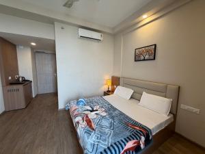 a bedroom with a bed with a blanket on it at Omaxe stay in Greater Noida