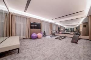 Großes Zimmer mit Fitnessraum mit Trainingsgeräten in der Unterkunft Echeng Hotel Hezhou Shizheng Square in Wuzhou