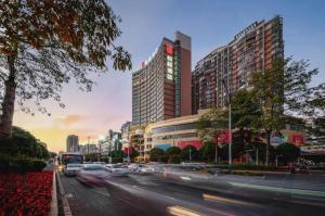 eine Stadtstraße mit Autos, die eine Straße mit hohen Gebäuden entlangfahren in der Unterkunft Echeng Hotel Hezhou Shizheng Square in Wuzhou