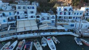 um grupo de barcos na água em frente aos edifícios em Faros Rooms em Loutró