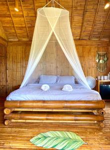 Ce lit se trouve dans un dortoir doté d'une moustiquaire. dans l'établissement Phuree Hut, à Ko Phayam