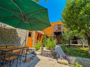 a patio with a table and a green umbrella at ErGarden in Byureghavan