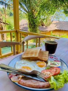 une assiette d'œufs et de toasts et un verre de soda dans l'établissement Phuree Hut, à Ko Phayam