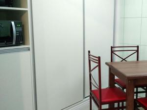 a kitchen with a table and two chairs and a microwave at HOTEL PAULISTANO Parque Anhembi in Sao Paulo