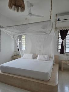 Un dormitorio con una cama blanca con dosel. en Kupenda House - Milele Resort Tamu, Watamu, en Watamu 43 fotos más