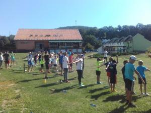 um grupo de pessoas em pé num campo a jogar frisbee em Turistická ubytovňa Hotel Divin em Divín