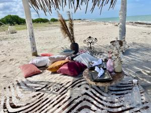eine Decke am Strand mit einem Tisch und Kissen in der Unterkunft Aiwa Hotel in Mayapo
