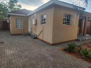 una pequeña casa con una entrada de ladrillo delante de ella en Luxe Residence Guest House, en Kasane 8 fotos más