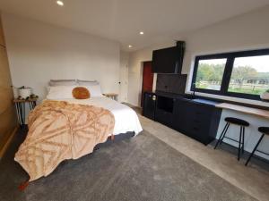 une chambre avec un lit et une grande fenêtre dans l'établissement Hidden Valley Waiheke, à Palm Beach