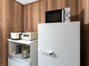 a white refrigerator with a microwave on top of it at 鶴羽リゾート in Sanuki