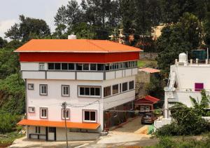 um edifício branco e laranja com um telhado laranja em AK Residency em Yercaud