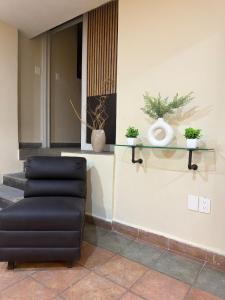 a black chair and some plants on a wall at 3 Acogedor apartamento en el corazón de Atlixco in Atlixco
