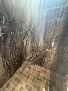 a bathroom with a stone shower with a tiled floor at 3 Acogedor apartamento en el corazón de Atlixco in Atlixco