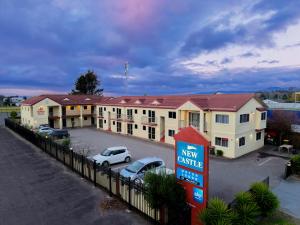 a view of a hotel with cars parked in a parking lot at New Castle Motor Lodge in Rotorua +21 photos