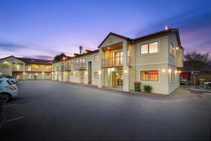 a row of apartment buildings with a parking lot at New Castle Motor Lodge in Rotorua