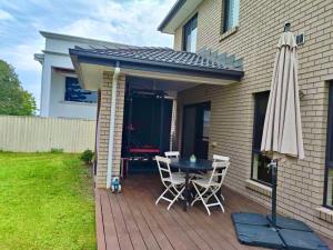 Un patio con una sombrilla y una mesa y sillas. en underwood MyHill, en Kuraby