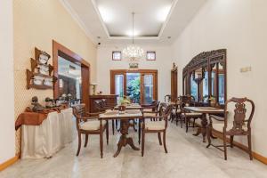 a dining room with tables and chairs and a chandelier at Urbanview De Ethnic Hotel Bandung by RedDoorz in Bandung