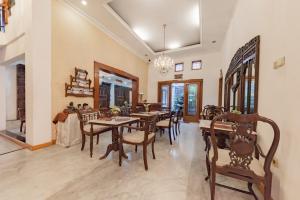 a dining room with wooden tables and chairs at Urbanview De Ethnic Hotel Bandung by RedDoorz in Bandung