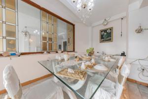 a dining room with a glass table and chairs at Urbanview De Ethnic Hotel Bandung by RedDoorz in Bandung