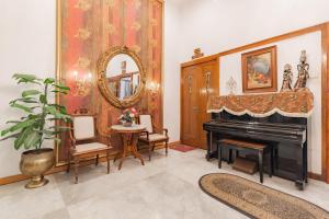 a living room with a piano and a mirror at Urbanview De Ethnic Hotel Bandung by RedDoorz in Bandung