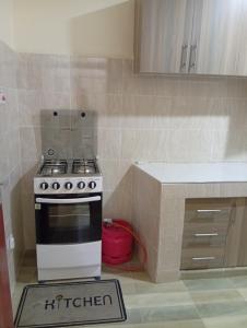a kitchen with a stove and a red pot on the floor at JO kitengela deluxe Two and one bedroom in Kitengela 