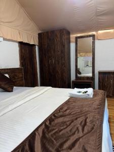a bedroom with a large bed with a large mirror at Satpura Adventure Resort in Pachmarhī +3 photos