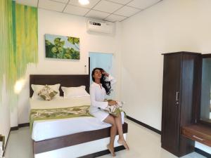 Una mujer sentada en una cama en una habitación. en Jonathan`s way, en Negombo 12 fotos más