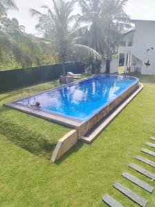 una gran piscina en un patio junto a una casa en Jonathan`s way, en Negombo