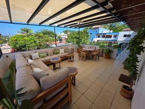 un patio con un divano e un tavolo su un balcone di Tayau Bungalows a Lo de Marcos