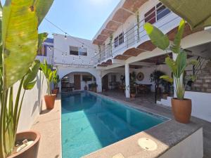 a villa with a swimming pool and plants at Tayau Bungalows Bungalow 2 in Lo de Marcos