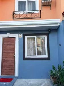 un edificio blu con una porta e una finestra di Mizteesaah's Stay a Mabalacat