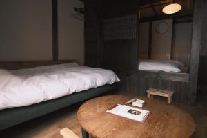 una habitación con dos camas y una mesa con un libro en Hotel Suzumeya Tsukiji plus kitchen, en Tokio