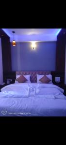 una camera da letto con un grande letto bianco con luci blu di Dreamworld Hotel a Panchgani Altre 5 foto