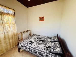 a bedroom with a bed with a black and white blanket at Nimsara Lodge in Hikkaduwa