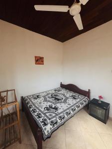 a bedroom with a bed and a ceiling fan at Nimsara Lodge in Hikkaduwa