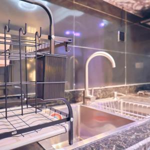 una cucina con lavandino e due rubinetti di Purple Lavender Court a Ikoyi