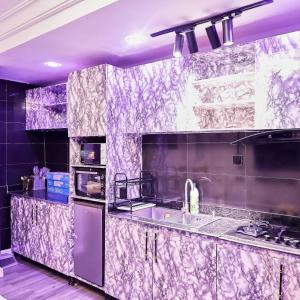 una cucina viola con lavandino e piano cottura di Purple Lavender Court a Ikoyi Altre 63 foto