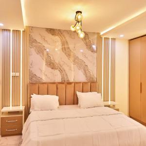 una camera da letto con un grande letto bianco con un dipinto sul muro di Purple Lavender Court a Ikoyi