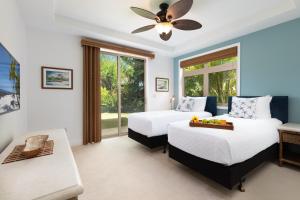 a bedroom with two beds and a ceiling fan at PINEAPPLE HALE Lovely 4BR KaMilo Home with Private Beach Access in Waikoloa +68 photos