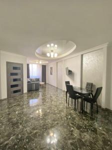 sala de estar con mesa y sillas en el suelo de mármol en Modern apartment nice view at Republic Squer, en Ereván